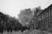 Menschen in Amstetten nach dem Bombenangriff vom 16. März 1945. Die Rauchsäule entstand während des Brandes einer Fabrik im Osten der Stadt aufgrund von Bombentreffern. (Foto: Stadtarchiv Amstetten)