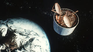 Das Bild zeigt die Zeichnung eines Satelliten. (Symbolfoto: An artist’s concept of the NATO Defense Satellite Communications System II satellite in orbit, gemeinfrei;Public Domain, Wikimedia Commons)
