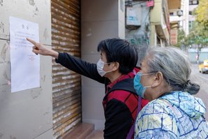 Bewohner lesen die Informationen auf einer Anschlagtafel. (Foto: zhizhou deng; CC BY 2.0)