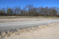 Nach diesen Arbeitsschritten ist der Straßenbelag grundsätzlich befahrbar. Nun wird das Gelände mit dem Straßenbankett angelegt. Zum Schluss kommt das Auspflocken der Straße mit Leitpflöcken. (Foto: Keusch)