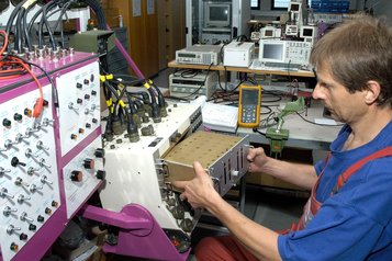 Währenddessen führt der Facharbeiter für IKT-Technik Instandsetzungsarbeiten am Armaturenbrett der Panzerhaubitze durch. (Foto: Norbert Tschermernjak)