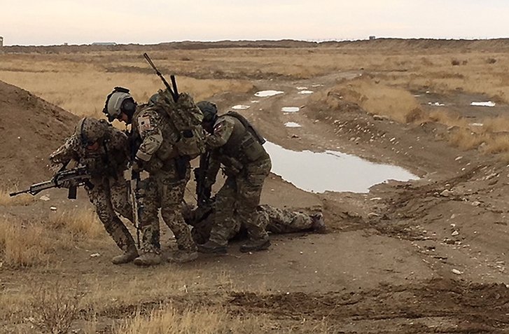 Deutsche und österreichische Soldaten ziehen den Übungsverletzten in den Schutz eines nahegelegenen Hügels. (Foto: Bundeswehr/Fischer)