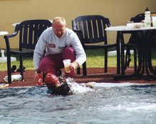 Herbert Egger reicht Luis ein Getränk und Verpflegung bei einem kurzen Schwimmhalt im 50-m-Becken bei seinem ersten Ultra-Triathlon in Neulengbach. (Foto: Werner Planer)