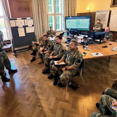Der Leiter der Stabsarbeit gibt den Einsatzbefehl an die Kompaniekommandanten und an die Kommandanten der unterstellten Einheiten. Entfernt eingesetzte Vertreter nehmen per Videokonferenz teil. (Foto: Bundesheer/Felix Höbarth)