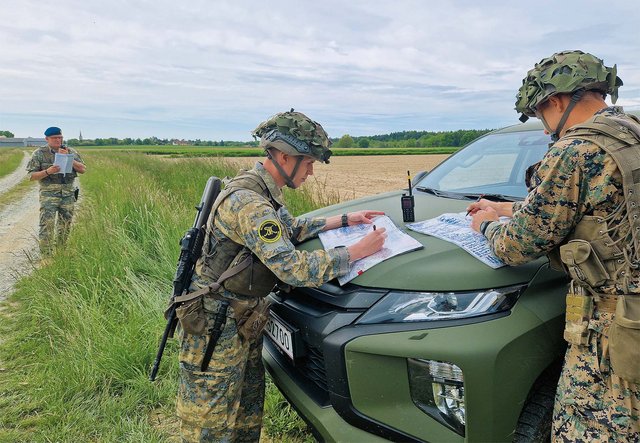 Ein Gastlehroffizier und Bataillonskommandant (li.) erteilt über Funk einen Gefechtsbefehl. Die Fähnriche zeichnen die Informationen und Vorgaben als Kompaniechefs in ihre Handkarten ein. So lernen sie die Einheit kennen, um als zukünftige Zugskommandanten die übergeordnete Ebene zu verstehen. (Foto: Bundesheer/Pierre Kugelweis)