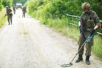 Rechts oben: Soldaten mit Minensuchgeräten überprüfen einen verdächtigen  Straßenabschnitt auf Sprengeinrichtungen. (Foto: Bundesheer/Philipp Winkler)