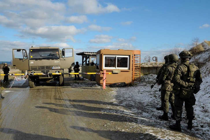 Kontrolle eines LKW am Checkpoint. Die Soldaten (re.) halten sich für die Durchsuchung des Fahrzeuges bereit. (Foto: Tesch)