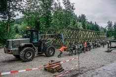 Soldaten des Pionierbauzuges schieben eine Baileybrücke ein. Zusätzlich zur Manneskraft kommt ein Radlader JCB346 zum Einsatz. (Foto: PiB2)