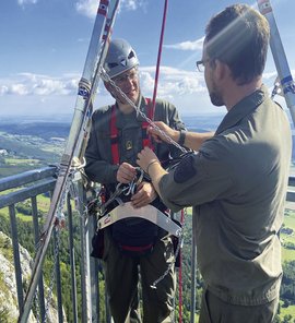 Lehrgangskommandant und Entwickler der PSAgAfA-Ausbildung im Bunderheer, Lukas Walter (rechts), erklärt vor der Verwendung die Eigenheiten des undurchtrennbaren Halteseiles und des Prototypen eines Sitzbrettes. (Foto: Bundesheer/Paul Strasser)