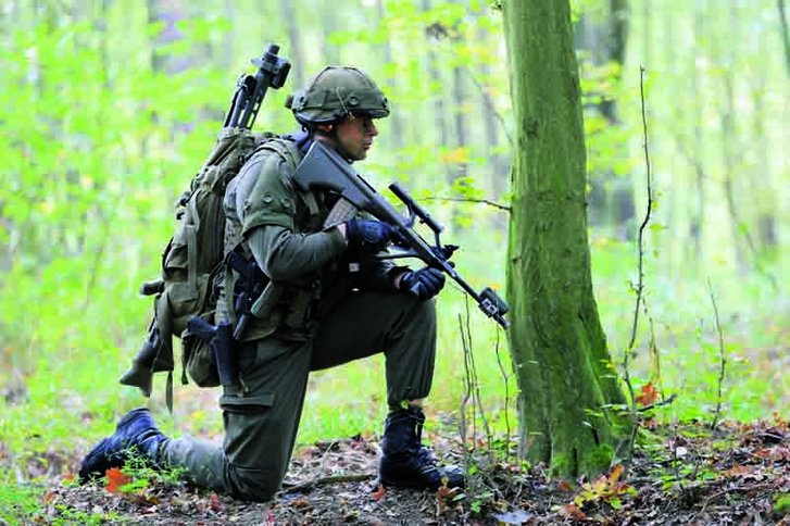 Ein Schütze mit aufgeschnalltem Maschinengewehr sichert das Gelände während eines Marschhaltes.(Foto: Planer)