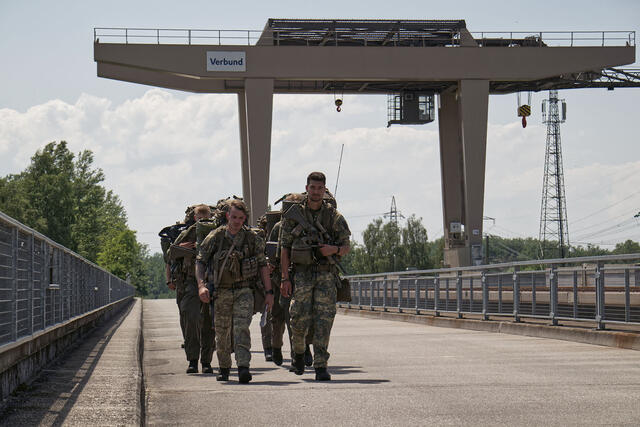Eine Ausbildungsgruppe marschiert während der Abschlussübung, einem Höhepunkt der Ausbildung, über ein Donaukraftwerk. (Fotos: Bundesheer/Andreas Ecker)
