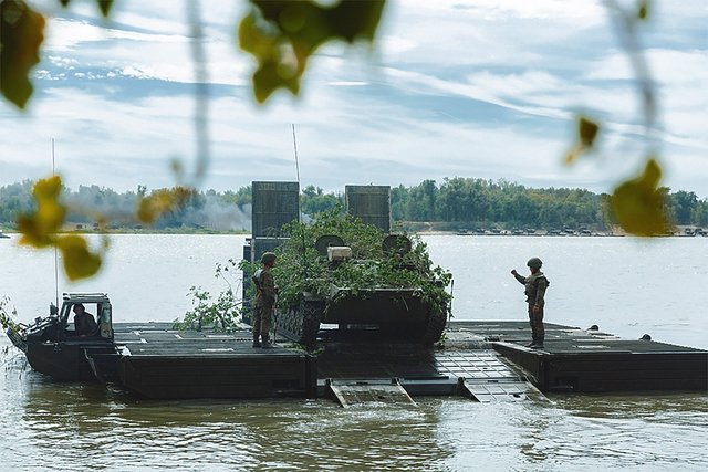 Ein Schützenpanzer übersetzt mit einer Schwimmfähre ein Wasserhindernis.(Foto: MoD Russia/gemeinfrei)