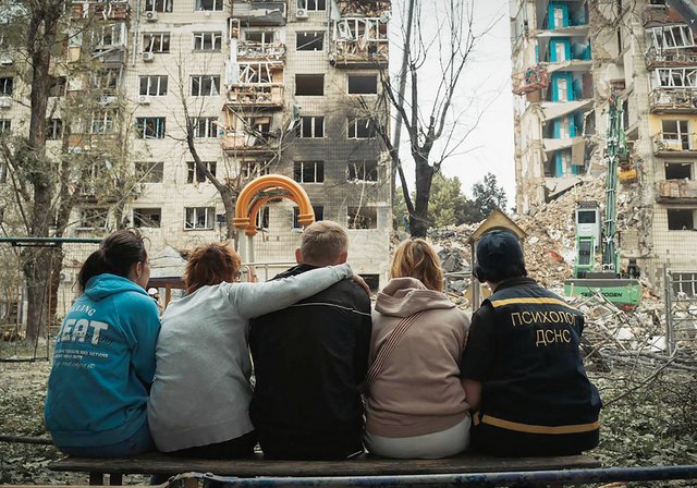 Menschen blicken auf zwei zerstörte Wohnhäuser in Kiew nach einem russischen Luftangriff im Juni 2025. (Foto: dsns.gov.ua; Cc BY-SA 4.0)