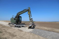 Ein Bagger füllt die Trasse mit der ersten Tragschicht und der Ausgleichsschicht. Danach wird die drei Zentimeter starke Fahrschicht mit feinem Schotter aufgetragen und gewalzt. (Foto: Keusch)