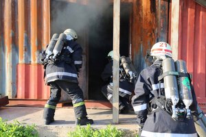 Die Campfeuerwehr übt möglichst realitätsnah: Ein Brandschutztrupp mit Atemschutzgeräten dringt in einen mit Rauch gefüllten Container ein. (Foto: Georg Rauchenwald)