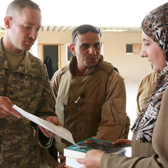 Ein US-Soldat übergibt Schulbücher an eine Lehrerin im Irak. (Foto: U.S. Army/Scott Schmidt; gemeinfrei)