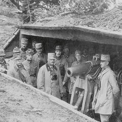 Offiziere und Panzerwerk-Soldaten stehen rund um eine 10-cm-Turmhaubitze. (Foto: Kriegsarchiv Wien; gemeinfrei)