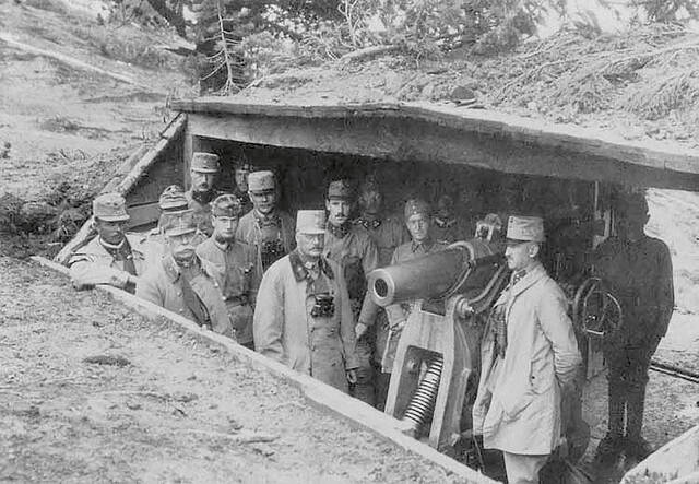 Offiziere und Panzerwerk-Soldaten stehen rund um eine 10-cm-Turmhaubitze. (Foto: Kriegsarchiv Wien; gemeinfrei)