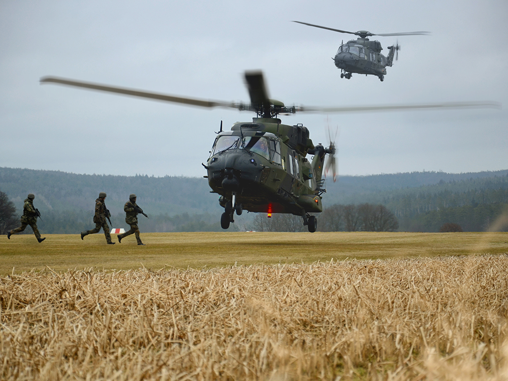 Auf dem Bild sieht man zwei landende Transporthubschrauber vom Typ NH90