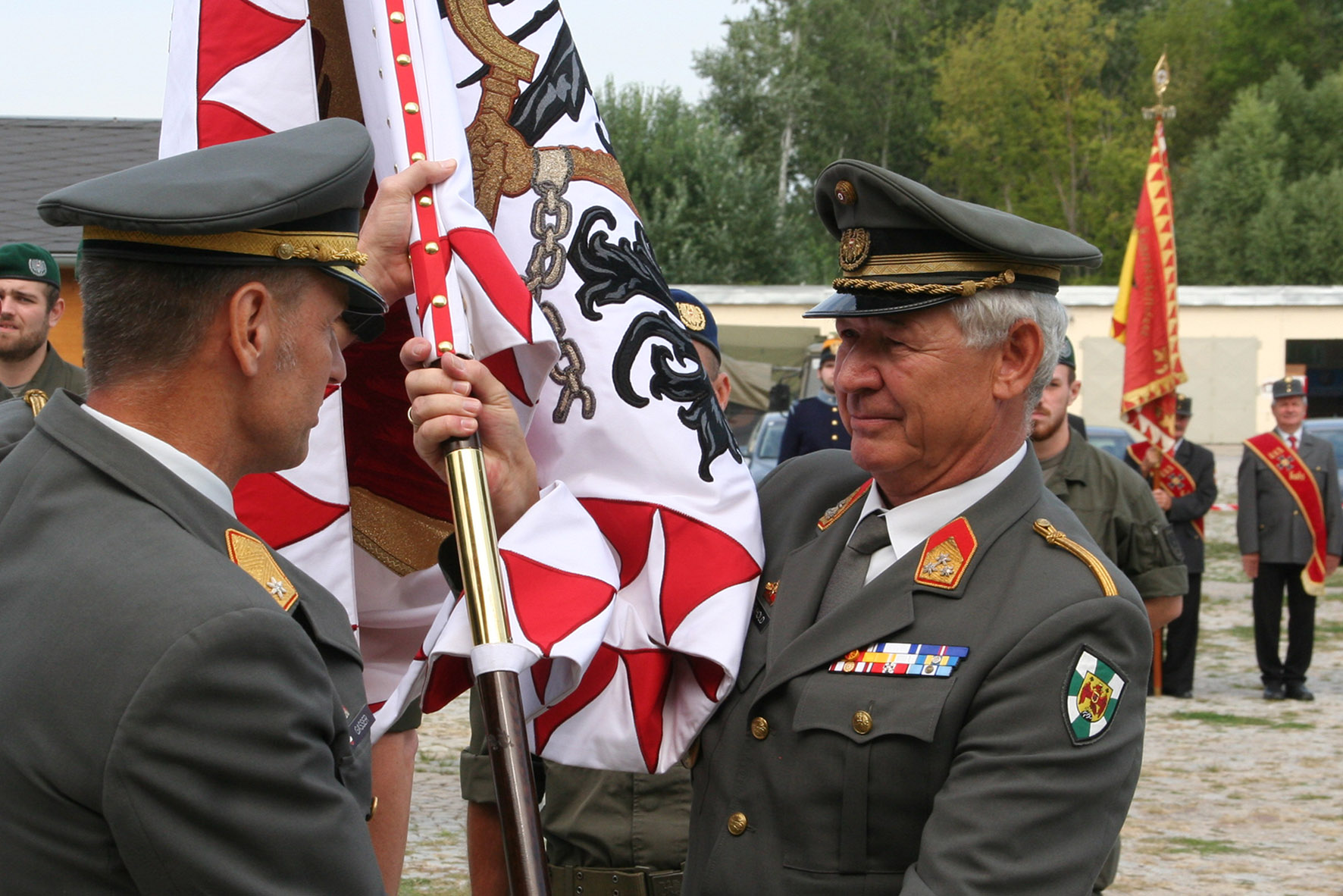 Der scheidende Kommandant des Truppenübungsplatzes Bruckneudorf, Oberst Franz Neuhold übergibt die Standarte des Truppenübungsplatzes an den Militärkommandanten des Burgenlands, Brigadier Gernot Gasser. (Foto: ÖBH/Hatos)