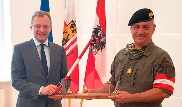 Brigadier Mag. Dieter Muhr übergibt Landeshauptmann Mag. Thomas Stelzer symbolisch einen geöffneten Schlagbaum mit Fieberthermometer. (Foto: BMLV/Gerhard Oberreiter)