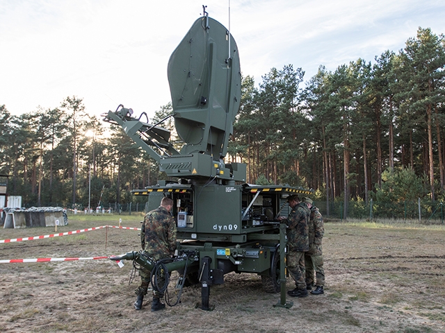 Soldaten stehen und arbeiten an einer SatCom-Anlage